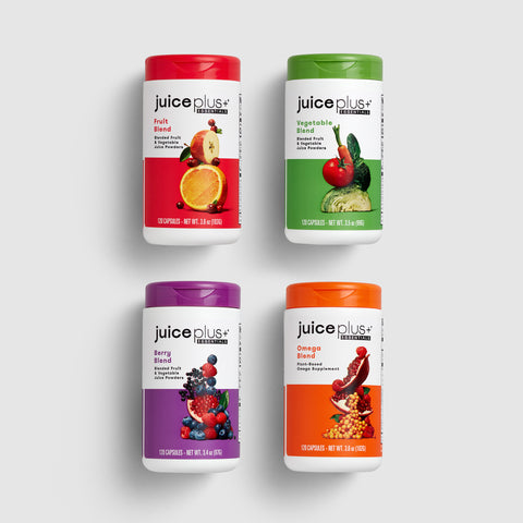 Four Juice Plus+ Essentials Capsules supplement on a white background