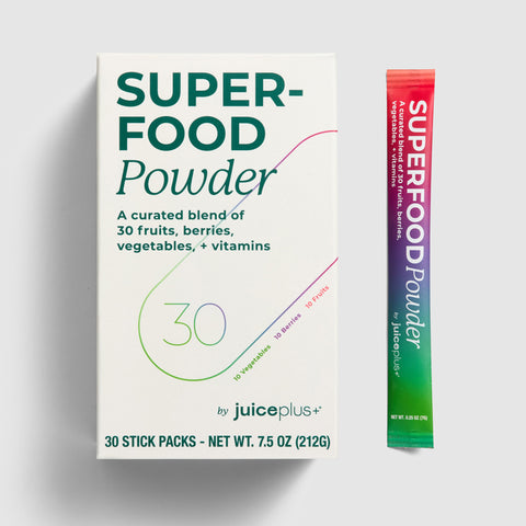 Juice Plus+Superfood powder package with a stick pack on a light gray background.