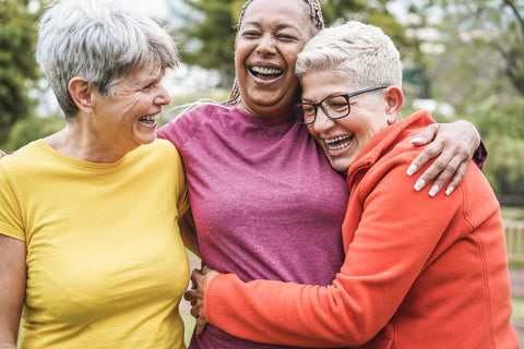 Image of three women outside hugging