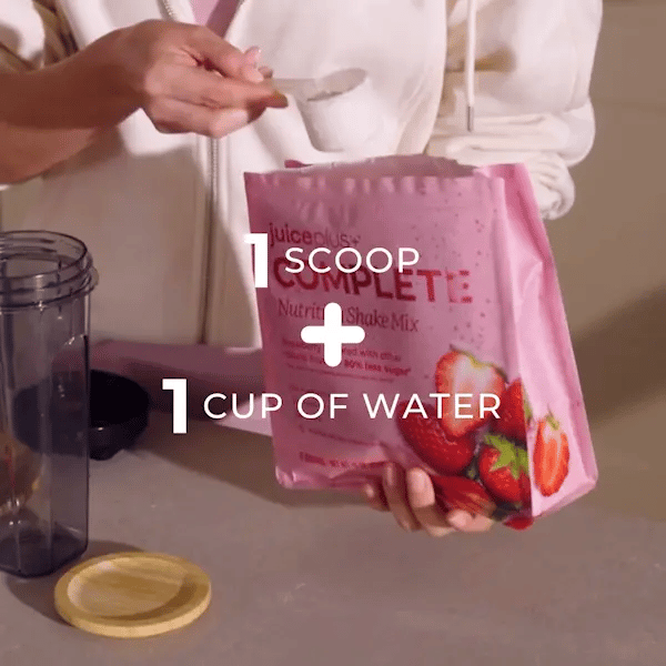 Person holding a pink package of Nutri-Complete shake mix with text overlay for preparation instructions.