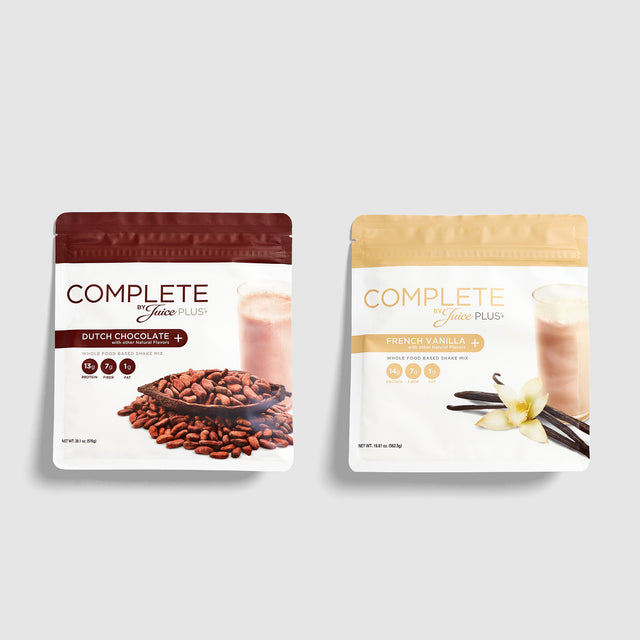 Two packages of Juice Plus+ Complete Vanilla and Chocolate on a light gray background