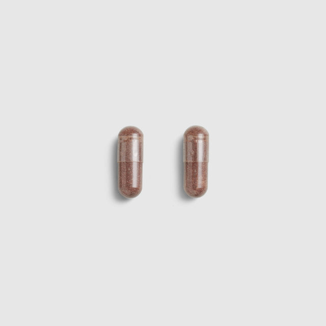 Two brown Juice Plus+ Capsules on a light gray background