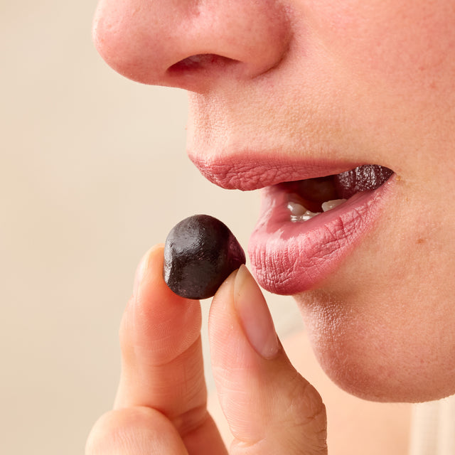 Close-up of a person holding and about to eat a Juice Plus+ chewable.