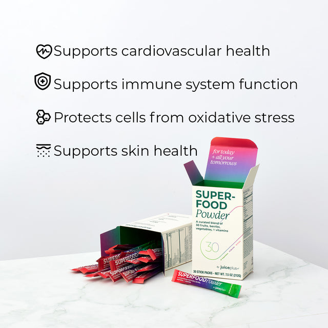 Juice Plus+ Superfood powder packets with a box on a white surface, featuring text about health benefits.