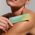 Person holding a Juice Plus+ Super-Biome Prebiotic package on their arm against a neutral background
