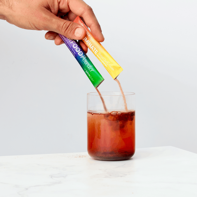 Luminate and superfood saches being added to glass of water
