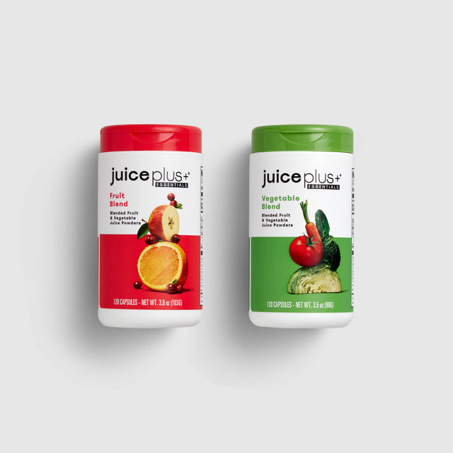 Two bottles of Juice Plus+ supplements, one labeled 'Fruit Blend' and the other 'Vegetable Blend'.